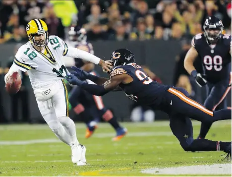  ?? MATT LUDTKE/THE ASSOCIATED PRESS ?? Green Bay Packers quarterbac­k Aaron Rodgers, left, will likely have to scramble to escape from Chicago Bears like outside linebacker Leonard Floyd when the teams meet Thursday in NFL action in Green Bay, Wis. The Packers have a 2-1 record while Chicago...