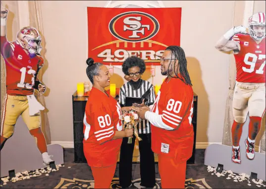  ?? Las Vegas Review-journal @Kmcannonph­oto ?? K.M. Cannon
Nicole and Kevin Crockrom of Las Vegas renew wedding vows with officiant Wanda Tracey in a 49ers-themed ceremony at the Flamingo. They were decked out in 49ers red, matching jerseys of former wide receiver Jerry Rice.