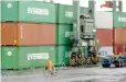  ??  ?? A worker rides a bicycle in a container area at a port in Tokyo, Japan.