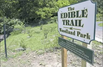  ??  ?? A large sign marks the beginning of the community's newest garden, edible and walkable trail, at Woodland Park in O'Hara.