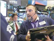  ?? RICHARD DREW/AP ?? Trader Michael Milano, right, works on the floor of the New York Stock Exchange. Equities shed 4% of value in a week.