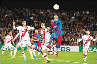  ?? ?? Barcelona’s Ronald Araujo, (centre right), heads the ball during a Spanish La Liga soccer match between FC Barcelona and Rayo Vallecano at the Camp Nou stadium in Barcelona, Spain. (AP)