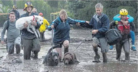  ?? Pictures: KENNETH SONG/REUTERS ?? Emergency crews rescue residents and dogs yesterday after deadly mudslides flooded the streets in Montecito, California