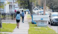  ?? REBECCA LURYE/HARTFORD COURANT ?? Children pass a pile of mattresses on their way home from school on Madison Street in Hartford’s Frog Hollow neighborho­od. The bulky waste was picked up the next day, but residents complain that furniture and mattresses are sometimes left at the curb by sanitation workers for weeks to months.