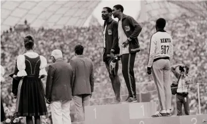  ?? Photograph: Bettmann/Bettmann Archive ?? Vincent Matthews (hand on hip) and Wayne Collett (barefoot, holding shoes) chat during the 400mmedal ceremony at the 1972 Olympics.