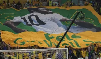  ?? ?? Football fans hold a giant Brazilian flag with a picture of Brazilian football legend Pele with a message "Pele, Get well soon" in Qatar, 2 December 2022