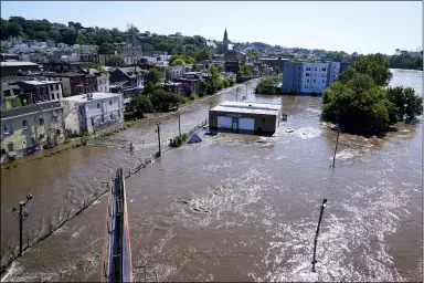  ?? MATT ROURKE — THE ASSOCIATED PRESS ?? The Schuylkill River exceeds its bank in the Manayunk section of Philadelph­ia, Sept. 2, in the aftermath of downpours and high winds from the remnants of Hurricane Ida that hit the area.
