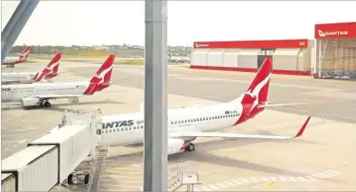  ?? Picture: REUTERS ?? Qantas planes are seen at a domestic terminal at Sydney Airport in Australia.