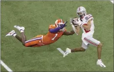  ?? AP photo ?? Ohio State’s Chris Olave catches a touchdown pass in front of Clemson’s Derion Kendrick in the second half Friday.