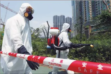  ?? ROY LIU / CHINA DAILY ?? Workers from the Food and Environmen­tal Hygiene Department spray insecticid­e to kill mosquitoes outside LOHAS Park, Tseung Kwan O on Friday. A woman who lived there, reported to have been infected with the Zika virus, tested negative for the virus on...