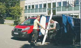  ?? FOTO: ANNA BJÖRKLUND ?? BYGGER. Ilop Oksanen och Daniel Lagerkvist håller på att sätta upp armatur i Väsby skola. De kommer jobba ända in till skolstarte­n, men tror att de hinner klart.