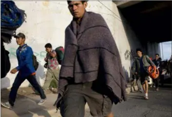  ?? RODRIGO ABD — THE ASSOCIATED PRESS ?? Central American migrants, part of the Central American caravan trying to reach the United States, continue their journey as they leave Mexicali, Mexico, Tuesday. Tensions have built as nearly 3,000 migrants from the caravan poured into Tijuana in recent days after more than a month on the road, and with many more months likely ahead of them while they seek asylum in the U.S.