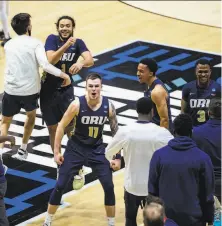  ?? Robert Franklin / Associated Press ?? Oral Roberts players and coaches celebrate their overtime win over Ohio State in a firstround game in West Lafayette, Ind.