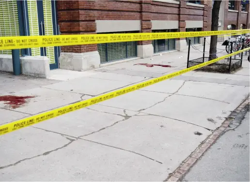  ?? Tyler ANDERSON / NATIONAL POST ?? Blood stains the sidewalk at King Street West and Portland Street where Anthony Smith and Muhammad Khattak were shot in late March. Both victims were members of the Dixon City Bloods street gang. Smith was killed in the shooting.