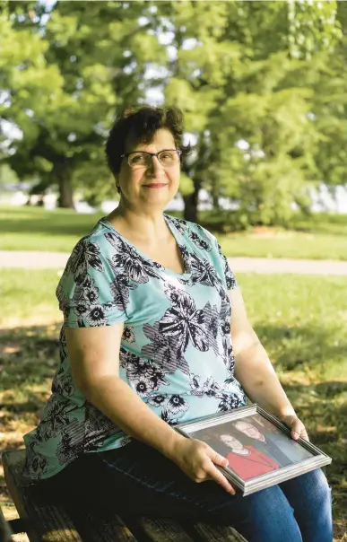  ?? NATOSHA VIA/THE NEW YORK TIMES ?? Dana Guthrie holds a portrait of her parents in Elizabetht­own, Ky. Many employees reduce their hours or stop working to help ailing family members, but it may be years before they fully return to the workforce.