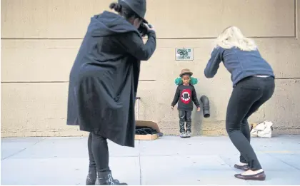  ??  ?? Princeton Cannon, five, stands by a hydrant as his mother, Keira, left, and Daisy Beatty, a profession­al photograph­er, take pictures.
LEFT