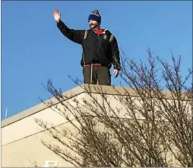  ?? GINGER RAE DUNBAR - DIGITAL FIRST MEDIA ?? Lionville Middle School Principal Jonathan Ross waves to students as they depart from school on Thursday. He camped out overnight on the school roof because the students and teachers raised more than $7,600 to benefit Alex’s Lemonade Stand during their...