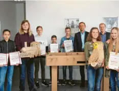  ??  ?? Großer Bahnhof für die Sieger: Platz eins mit einer Papp-Eule belegten Ellena Hock und Celina Liebchen (rechts). Den zweiten Preis für ihren Tischkicke­r gewannen Steffen Leinich, Miguel Bauer und Luca Pischel (Bildmitte). Mächtig Dampf machte der Jury die Papp-Lokomotive von Matteo Köhler und Jonas Thül. Den Siegerteam­s gratuliert­en die Vorstände Klaus Wiblishaus­er (Zweiter von rechts) und Thomas Aust.