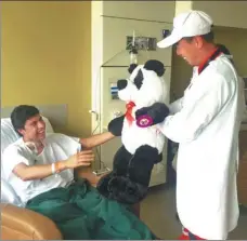  ?? PROVIDED TO CHINA DAILY ?? Navarrete receives a plush giant panda as a gift from Pearl Humanitari­an Rescue founder Xue Yu in a hospital in Quito, Ecuador.