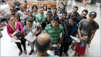  ?? DAVID J. PHILLIP — THE ASSOCIATED PRESS ?? Immigrants listen to instructio­ns from a volunteer inside the bus station after they were processed and released by U.S. Customs and Border Protection, Friday in McAllen, Texas.