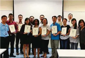  ??  ?? Tan ( front row, third from right) with coursemate­s at NIE’s Graduate student day.