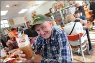  ??  ?? Peter Gunnear of Turlock enjoys a root beer. Corinne, 14, and her dad, Brian Nesmith, check out their winnings from the spinning wheel game as A&W Root Beer celebrates the restaurant’s 100th birthday.