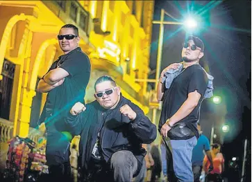  ??  ?? En el centro histórico. Angel Ednite, Fat Lui y Eddy XP, vocalistas de Pescozada, durante la producción del video “De aquí soy” realizada en el centro de San Salvador.
