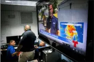  ?? RAMON ESPINOSA — THE ASSOCIATED PRESS ?? Emergency Center personnel stand next to a television screen showing a meteorolog­ical image of the tropical storm Dorian, as they await its arrival Wednesday in Ceiba, Puerto Rico.