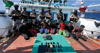  ?? — AFP photo ?? Indian commandos stand guard with a group of detained pirates after the Indian Navy freed an Iranian fishing vessel hijacked by Somali pirates, off the Somali coast 1,574 kilometres west of the Indian city of Kochi.