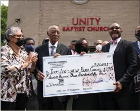  ?? Drew Angerer/getty Images North America/tns ?? Flanked by Rev. John J. Nicholas Jr. (2nd-l), pastor at St. John’s Baptist Church, and Rev. Charles Mcneill (3rd-r), Texas Legislativ­e Black Caucus (TXLBC) Chair Rep. Nicole Collier (D-fort Worth) accepts a donation check from the Missionary Baptist Ministers Conference of Washington, DC and Vicinity at the end of a news conference about voting rights at Unity Baptist Church on July 26 in Washington, DC.