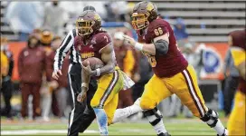  ?? ?? Central Michigan running back Lew Nichols heads upfield as lineman Tyden Ferris looks for a Washington State player to block during the second half Friday.