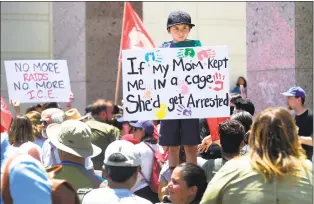  ?? Frederic J. Brown / AFP/Getty Images ?? In this file photo taken on June 30, people hold placards during a “Families Belong Together” march and rally in Los Angeles. Thousands more children were forcibly separated from their parents after illegally crossing the US-Mexico border from 2017-2018 than originally admitted by the Trump administra­tion, an official report said Thursday.