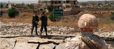  ?? Photo: Andrey Borodulin/ AFP/Getty Images ?? Amemberof the Russian military police and Syrian government forces patrol near the village al-Hamidia in the Syrian Golan Heights.