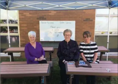  ?? BILL DEBUS — THE NEWS-HERALD ?? From left: Joyce McCracken Bortner, Judy McCracken and Sandy McCracken Gurgovits sit at tables in the Mary Lou McCracken Outdoor Classroom on May 24. The learning area is located in the courtyard at North Elementary School in Madison Township. They are all sisters of Mary Lou McCracken, a former teacher in the building when it was Red Bird Middle School. The McCracken family donated money to create the Outdoor Classroom in memory of Mary Lou, who died in October at age.