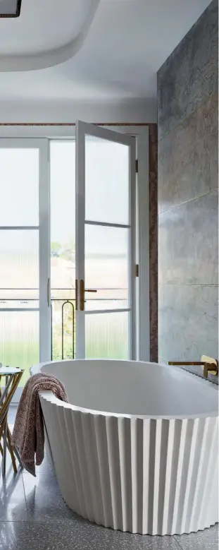  ??  ?? LEFT TO RIGHT
Glass mosaic tiles form visually arresting motifs on the bathroom walls; the vintage Murano glass chandelier in the bedroom is a whimsical touch; this bathtub by Kelly Hoppen was inspired by the art of origami; the family and guests can dine under the stars in this outdoor space