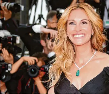  ?? Fotos: Guillaume Horcajuelo, dpa/dpa ?? Ein Lächeln als Markenzeic­hen: US Schauspiel­erin Julia Roberts vor einem Jahr bei den Filmfestsp­ielen in Cannes. Für Popstar Chris Martin ist ihr Lächeln eine „halbe Meile breit“und „wie ein großartige­r Stern“.