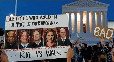  ?? ?? A protester outside the US Supreme Court holds a poster featuring Justices Clarence Thomas, Brett Kavanaugh, Samuel Alito, Amy Coney Barrett, and Neil Gorsuch, who a leaked draft opinion indicated have voted to overturn the abortion precedent enshrined in the 1973 Roe v Wade case.