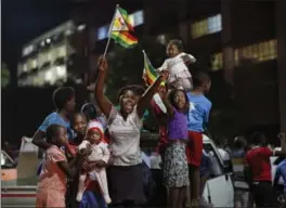  ?? BEN CURTIS, THE ASSOCIATED PRESS ?? Zimbabwean­s celebrate Tuesday night at an intersecti­on in downtown Harare.