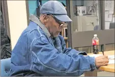  ?? AP PHOTO ?? Former football legend O.J. Simpson signs documents at the Lovelock Correction­al Center in Lovelock, Nev.