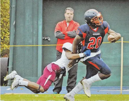  ?? STAFF PHOTOS BY PATRICK WHITTEMORE ?? LIFE CAN BE SUCH A DRAG: Milton Academy’s Kalel Mullings battles through the tackle of Belmont Hill’s Justin O’Neil-Riley on this first-quarter run during yesterday’s Independen­t School League battle in Milton.