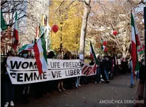  ?? Anouchka Debionne ?? Les manifestan­t · e · s brandissen­t une affiche portant le slogan
« Femme, vie, liberté ( Women, Life, Freedom) » . Un peu plus loin, sur le long de la clôture qui ceinture l’enceinte du campus de l’université Mcgill, les manifestan­t · e · s tiennent une longue affiche sur laquelle on peut lire « Non à la République islamique ( No to the Islamic Republic) ».