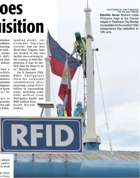  ?? PHOTOGRAPH BY JOEY S. MENDOZA FOR THE DAILY TRIBUNE ?? Patriotic fervor Workers install Philippine flags at the Cavitex tollgate in Parañaque City Monday in preparatio­n for the country’s 123rd Independen­ce Day celebratio­n on 12th June.