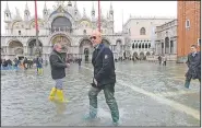  ?? AP/ANDREA MEROLA ?? Gianluca Vialli, a former Italian soccer star, walks through St. Mark’s Square in Venice on Saturday as the national soccer team and its staff makes a visit to view the flooding.