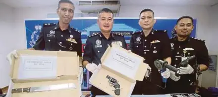  ?? [Foto Muhammad Zuhairi Zuber /BH] ?? Mohd Nor Yhazid (dua dari kiri) menunjukka­n pistol dan senjata yang dirampas daripada suspek pada sidang media di Ibu Pejabat Polis Daerah Melaka Tengah, semalam.