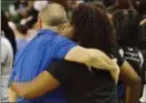  ?? KYLE FRANKO — TRENTONIAN PHOTO ?? Trenton Catholic head coach Bob Fusik, left, hugs assistant Sharika Salmon, right, after defeating Pennington in the MCT final at the Cure Insurance Arena on Thursday night.