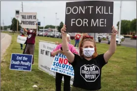  ?? (AP/Michael Conroy) ?? Death-penalty protesters hold up signs on the side of a road Wednesday in Terre Haute, Ind.