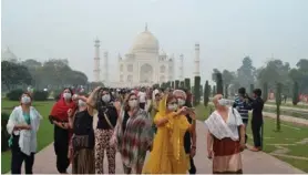  ?? AFP ?? Turistas extranjero­s usaban máscaras mientras visitaban el mausoleo del Taj Malal, en Agra, a 250 kilómetros de Nueva Delhi.