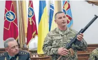  ??  ?? A Ukrainian military commander shows a rifle seized from Russian soldiers as Colonel-general Viktor Muzhenko, Chief of the General Staff and Commander-in-Chief of the Armed Forces of Ukraine, looks on during a news conference in Kiev.