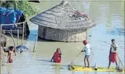  ??  ?? People wade through flood waters on a banana raft in Hajipur, Bihar, on Wednesday. PTI PHOTO