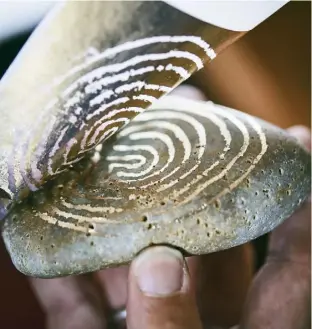  ??  ?? Jackie also likes to focus on magical and mythical themes, dreaming up fairy tales for her storybooks; in keeping with this, she paints pebbles found on the shoreline with labyrinth designs in gold leaf